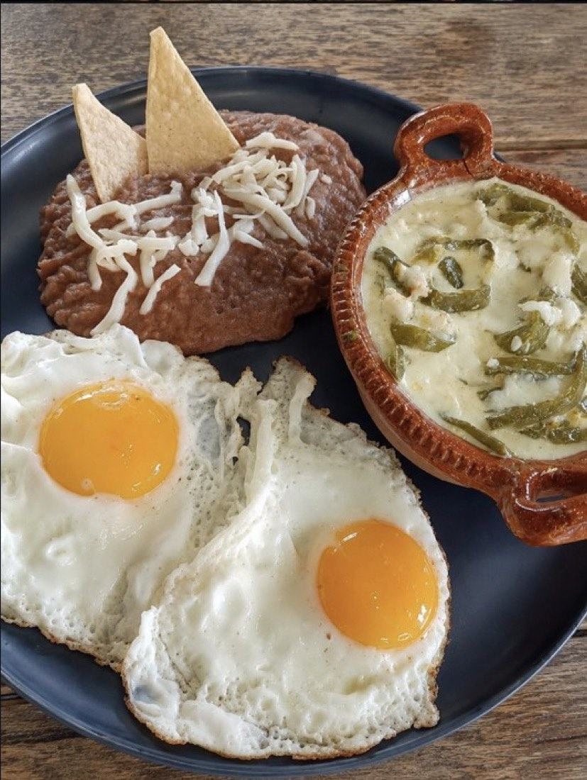 Desayuno con huevos, frijoles gratinados y rajas con crema