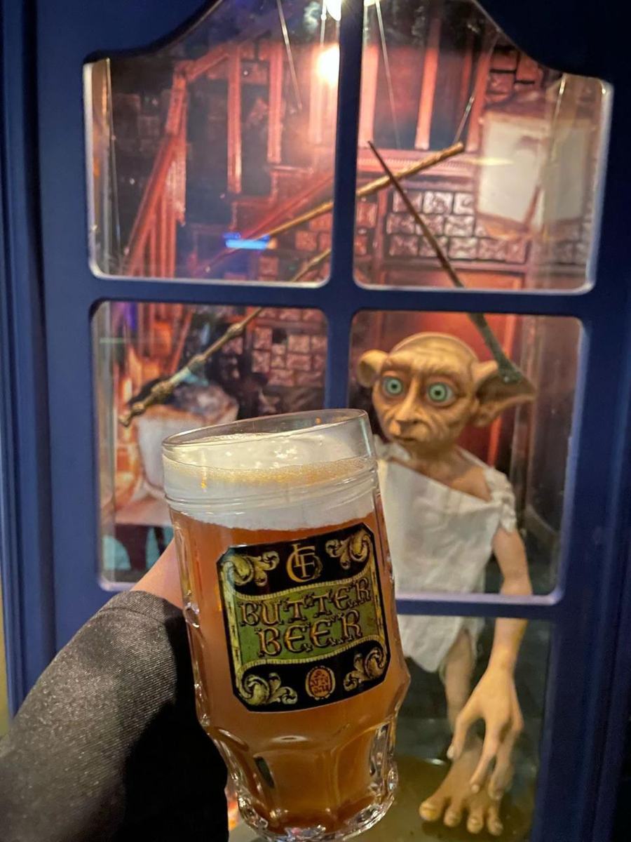 Brindis con cerveza de mantequilla frente a la vitrina de Dobby