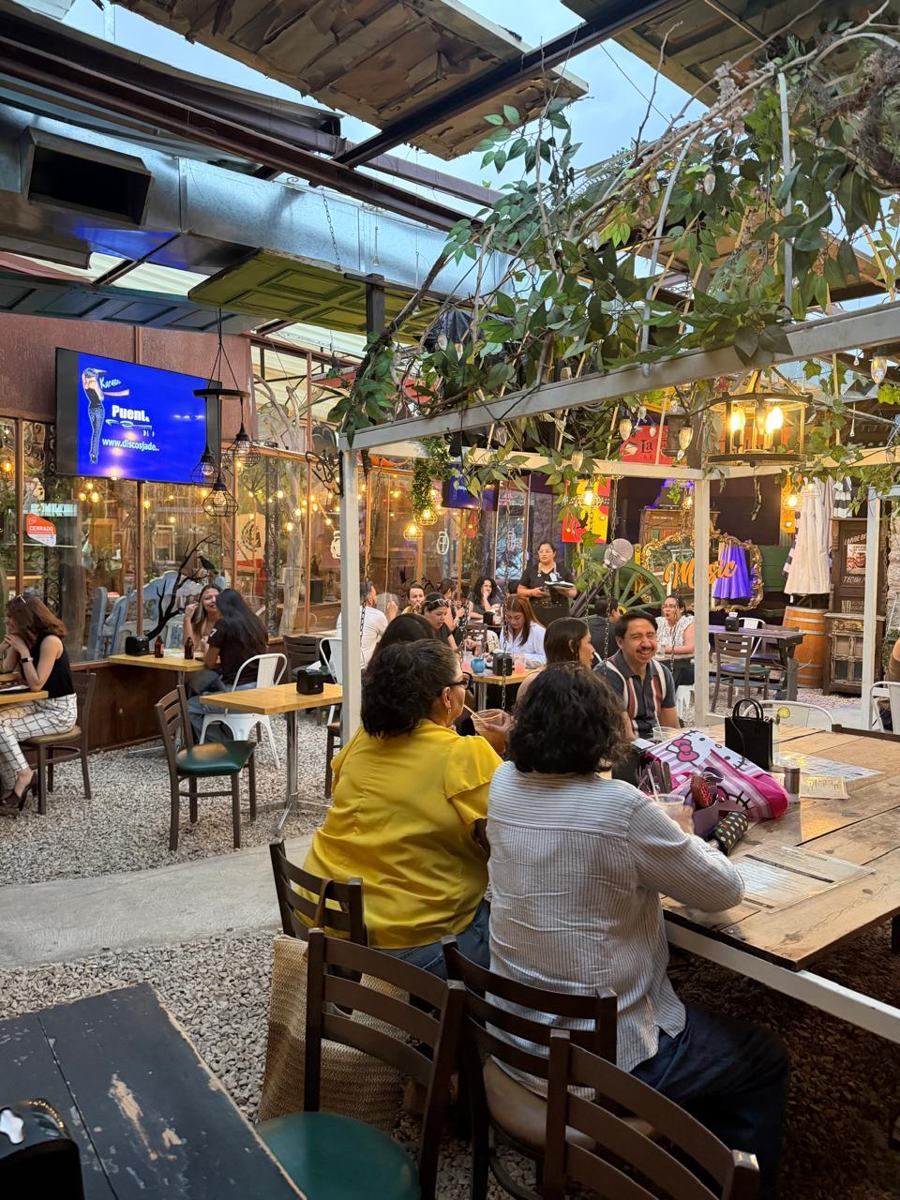 Ambiente de noche en Jardín Madame con mesas llenas y buena vibra